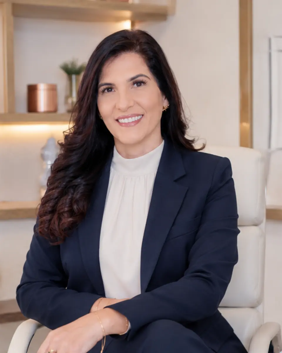 Dra. Sandra Quaresma em traje social, sentada em retrato profissional